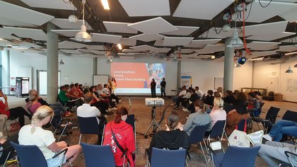 Menschen im Stuhlkreis hören bei Präsentation zu