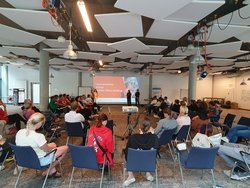 Menschen im Stuhlkreis hören bei Präsentation zu
