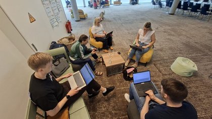 Gruppenarbeit an Laptops drinnen