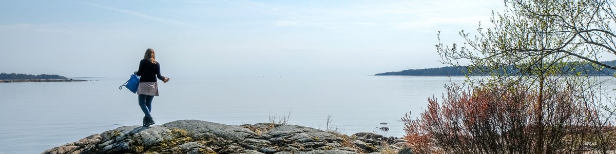 Junge Person an einem Ufer in der Nähe des Sees Värnen, Schweden