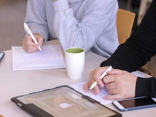 Two participants are taking notes.
