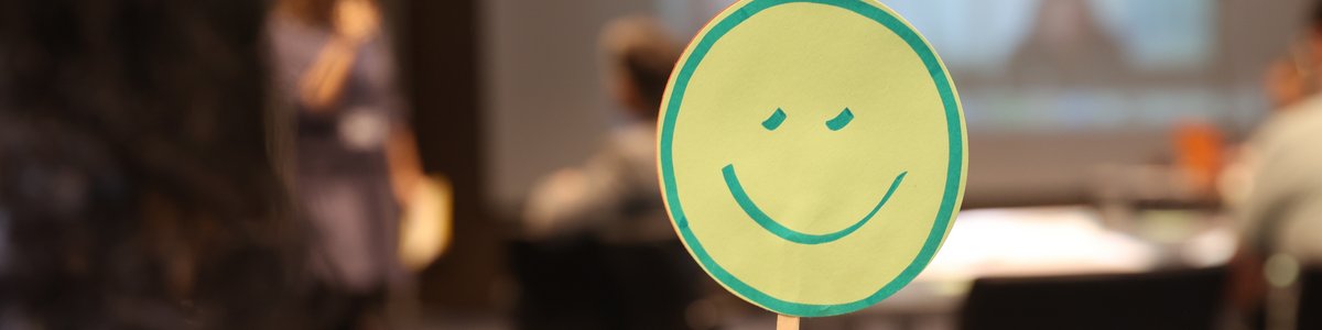 Someone is holding up a smiley sign.