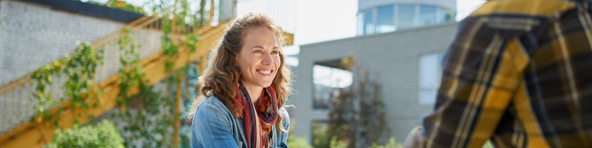 Freundlicher junger Mensch, der einen Bio-Gemüsestand auf einem Markt betreut