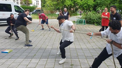 Teilnehmende machen Tauziehen draußen