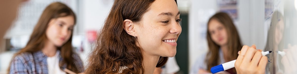 Junger Mensch schreibt auf Whiteboard