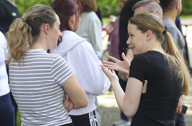 Zwei Frauen, von schräg hinten fotografiert, unterhalten sich.