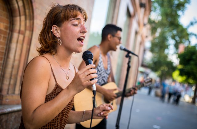 Junge Menschen musizieren auf einer belebten Straße