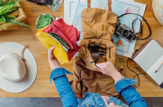 Draufsicht auf eine junge Person, die für ihre Reise packt