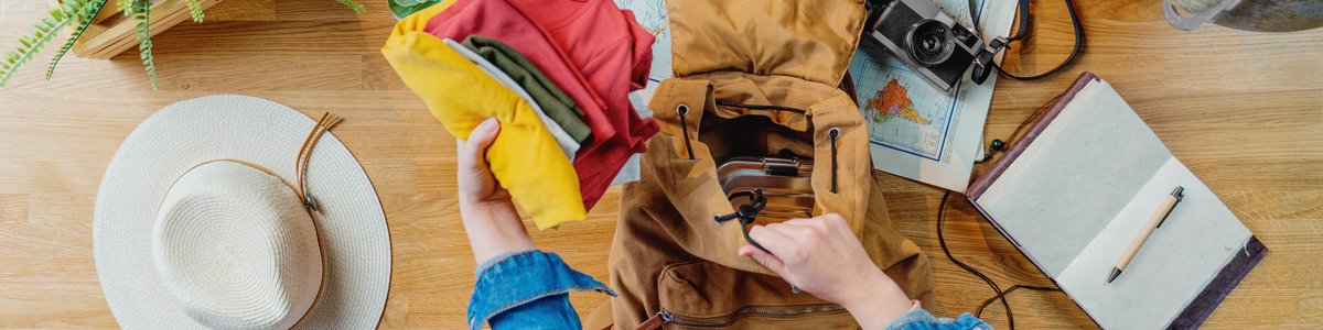 Draufsicht auf eine junge Person, die für ihre Reise packt