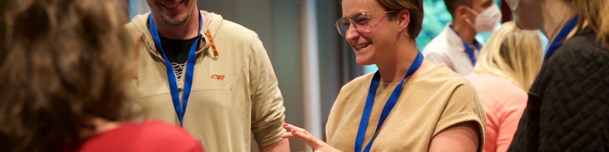 A group is standing together and a woman is talking