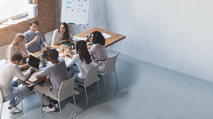 Team, das rund um einen Tisch sitzend diskutiert