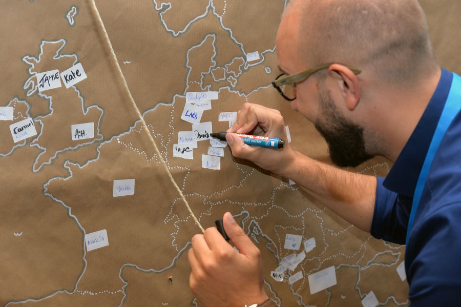 Mann vor einer Moederationswand, auf der die Umrisse Europas abgebildet sind