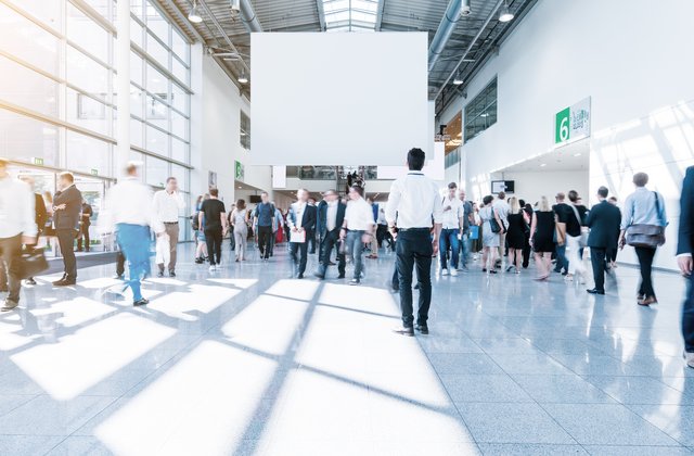 Geschäftige Menschen in einer Messehalle