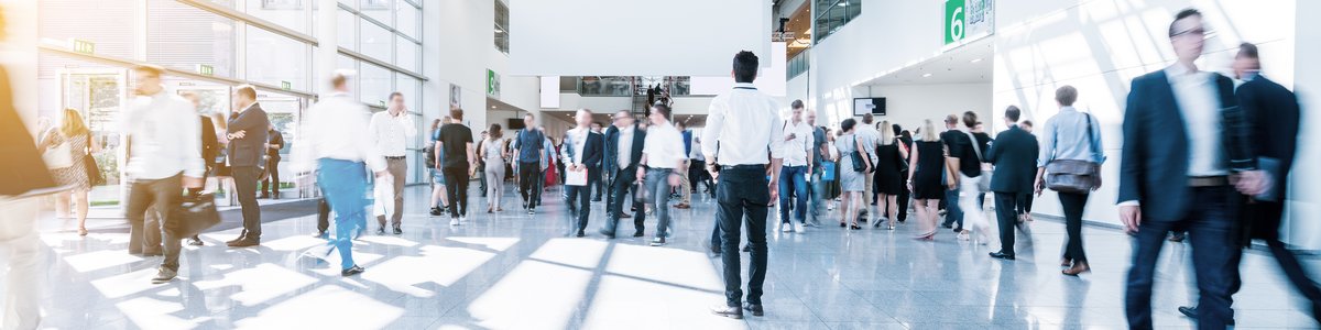 Geschäftige Menschen in einer Messehalle