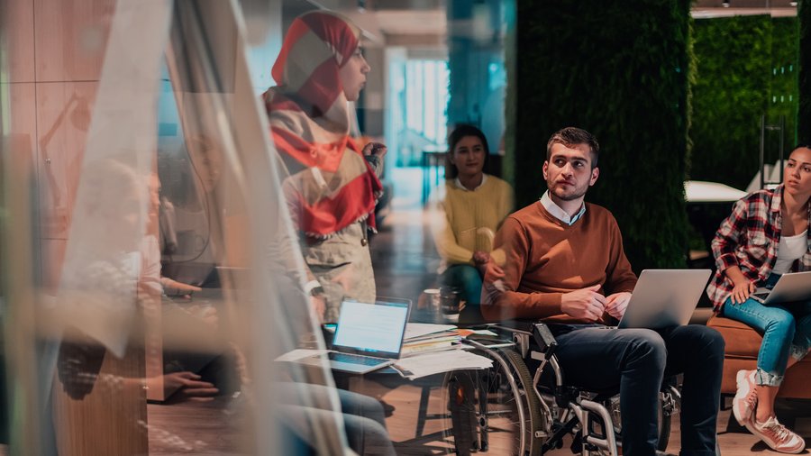 Eine Person hält vor einem vielfältigen Team ein Präsentation