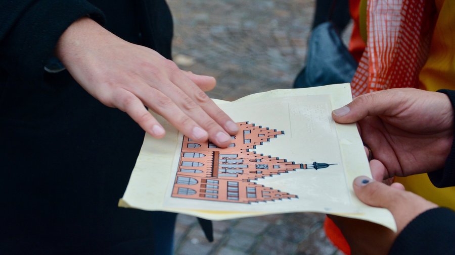 Teilnehmende eines Seminars ertasten ein Bild