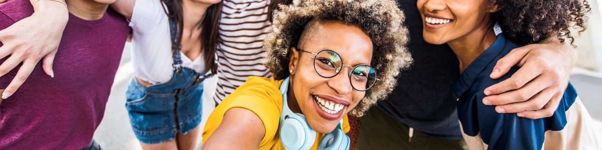 Mehrere junge Menschen haben Spaß beim Aufnehmen eines Gruppen-Selfies auf einer Straße in der Stadt