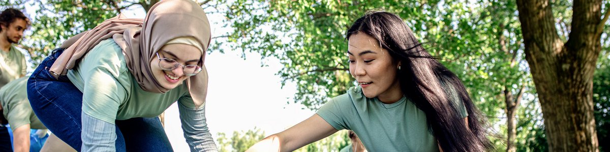 Gruppe von Freiwilligen mit Müllsäcken reinigt Stadtpark